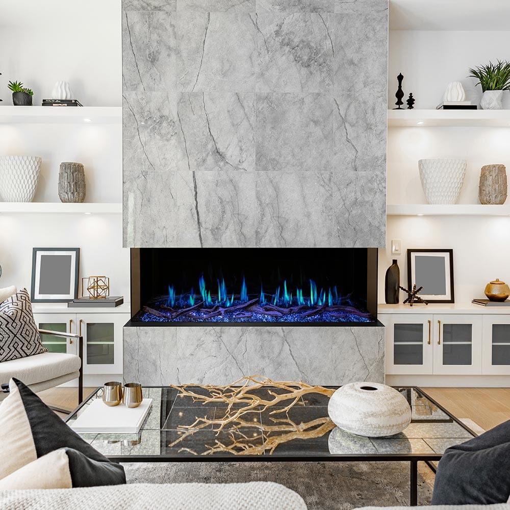 Linear electric fireplace with blue flames and log-style ember bed in wall niche